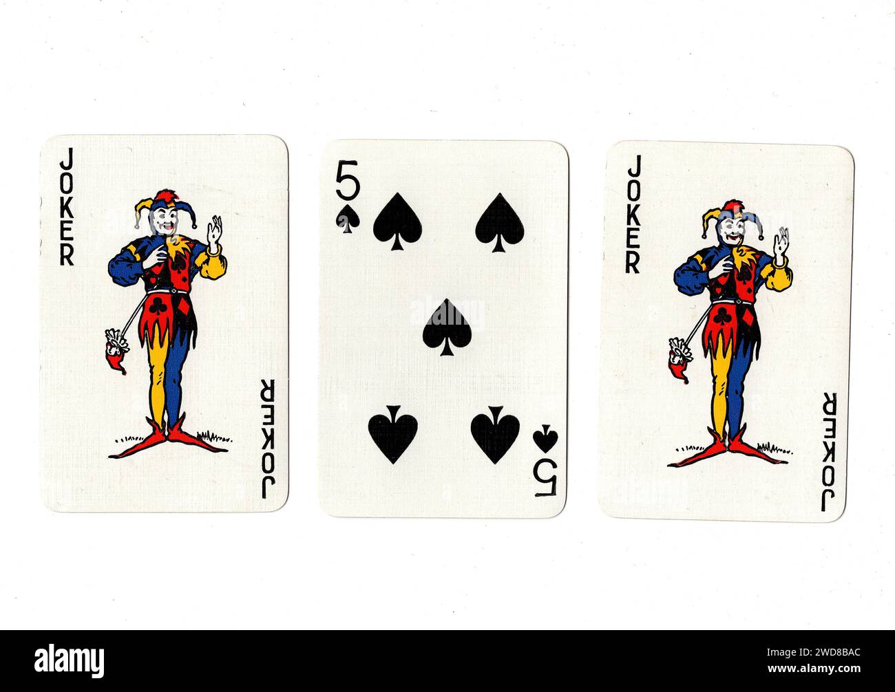 Cartes à jouer vintage montrant une paire de jokers et un cinq noir isolé sur un fond blanc. Banque D'Images