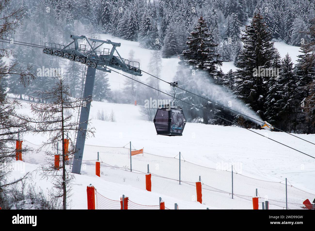 Télécabine de ski se déplaçant sur la piste de ski avec canon à neige à Val-Cenis, France Banque D'Images