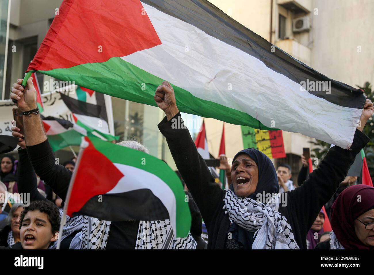 Beyrouth, Liban. 19 janvier 2024. Des manifestants palestiniens et libanais brandissent des drapeaux palestiniens lors d'une manifestation pour remercier l'Afrique du Sud d'avoir déposé une plainte contre Israël devant la Cour internationale de Justice (CIJ) pour génocide à Gaza. Des dizaines de réfugiés libanais et palestiniens se sont rassemblés devant l'ambassade d'Afrique du Sud à Beyrouth pour exprimer leur gratitude pour sa position dans la guerre continue israélo-Hamas dans la bande de Gaza. Crédit : Marwan Naamani/dpa/Alamy Live News Banque D'Images
