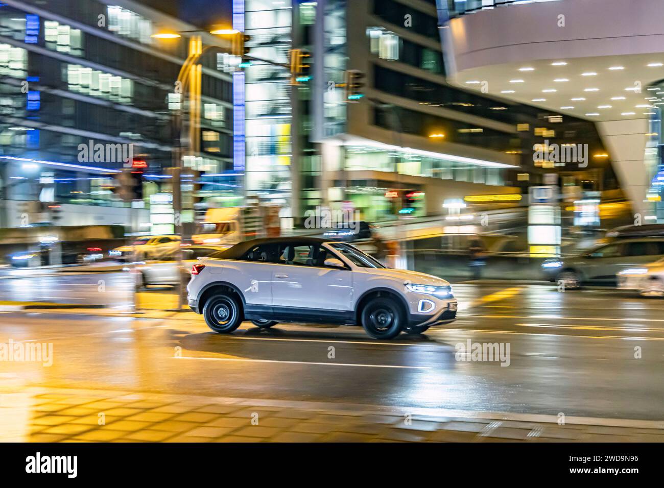 Innerstädtische Straße mit Fahrzeugen, moderne Architektur am Abend. Bewegungsunschärfe. VW T-Roc Cabriolet. // 17.01.2024 : Stuttgart, Bade-Württemberg, Deutschland. *** Rue de la ville avec des véhicules, architecture moderne dans le soir Motion Blur VW T Roc Cabriolet 17 01 2024 Stuttgart, Baden Württemberg, Allemagne Banque D'Images