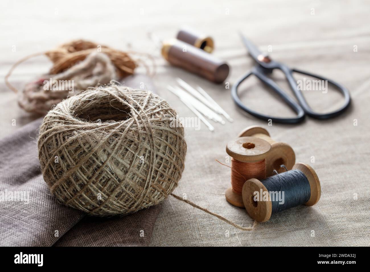 Concept de travaux d'aiguille. Divers outils de couture. Aiguilles, ciseaux, bobines, fils de différentes couleurs. Accessoires de couture et tissu Banque D'Images