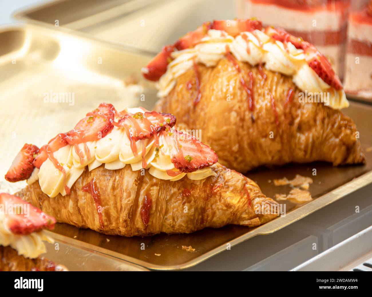 Le pain aux fraises de forme exquise est placé sur un plateau en acier, éclairé par des lumières chaudes, et est très délicieux. Banque D'Images