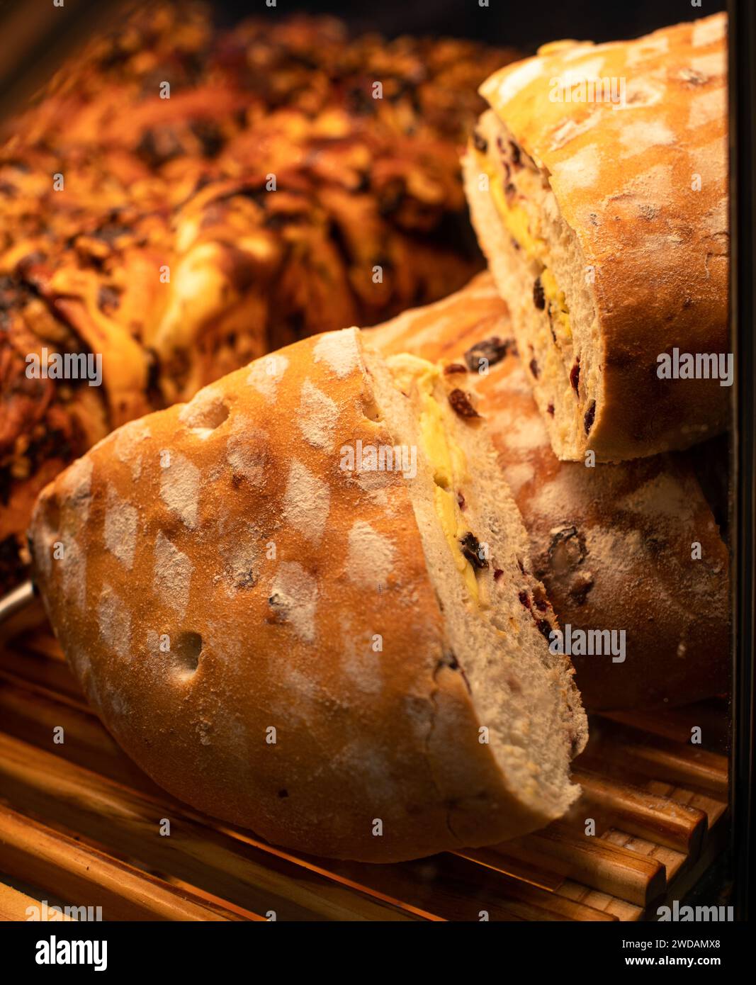 Le délicieux pain placé sur des étagères en bois, ces pains ont des formes exquises et sont éclairés par des lumières chaudes. Banque D'Images