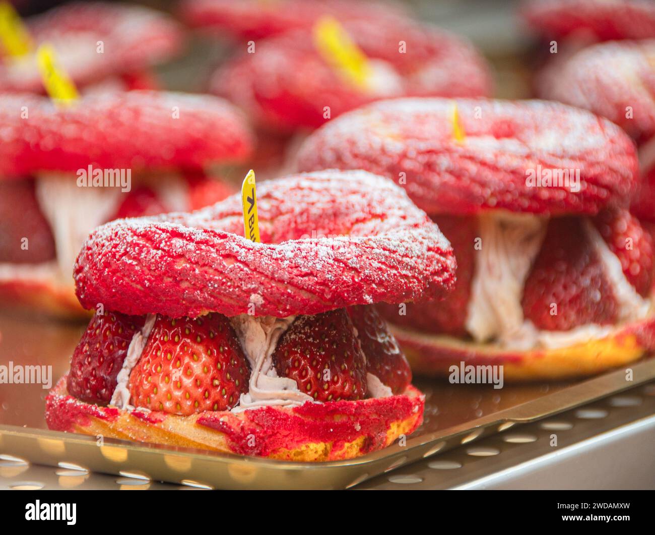 Le pain aux fraises de forme exquise est placé sur un plateau en acier, éclairé par des lumières chaudes, et est très délicieux. Banque D'Images