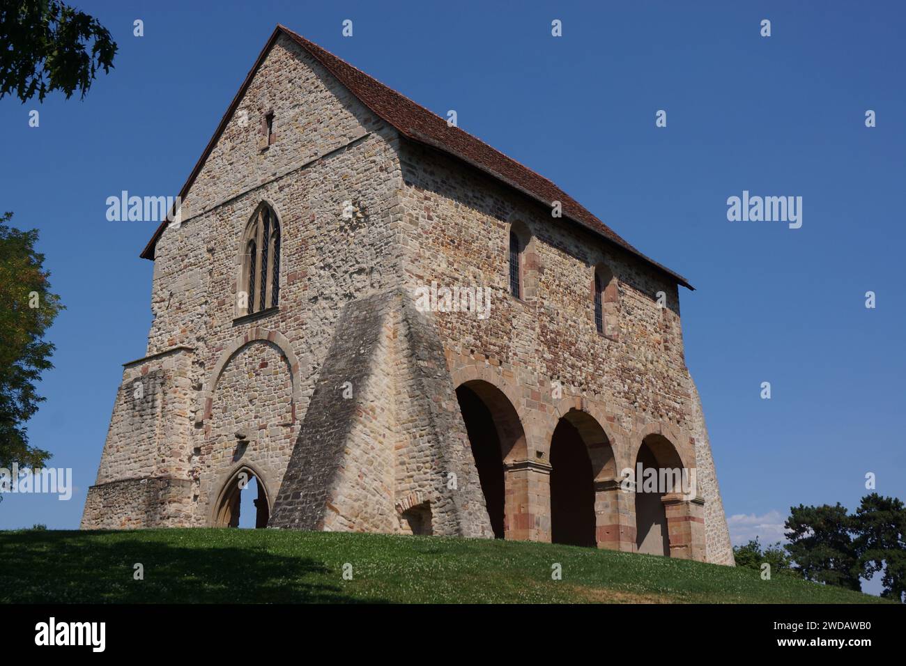 Vieille église en pierre avec fenêtre ouverte, nichée près de l'arbre Banque D'Images