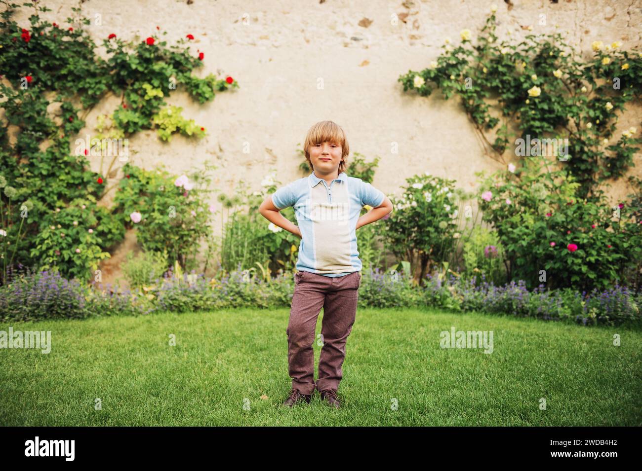 Portrait à l'ancienne en plein air d'un mignon petit garçon portant un pantalon court bleu et marron Banque D'Images