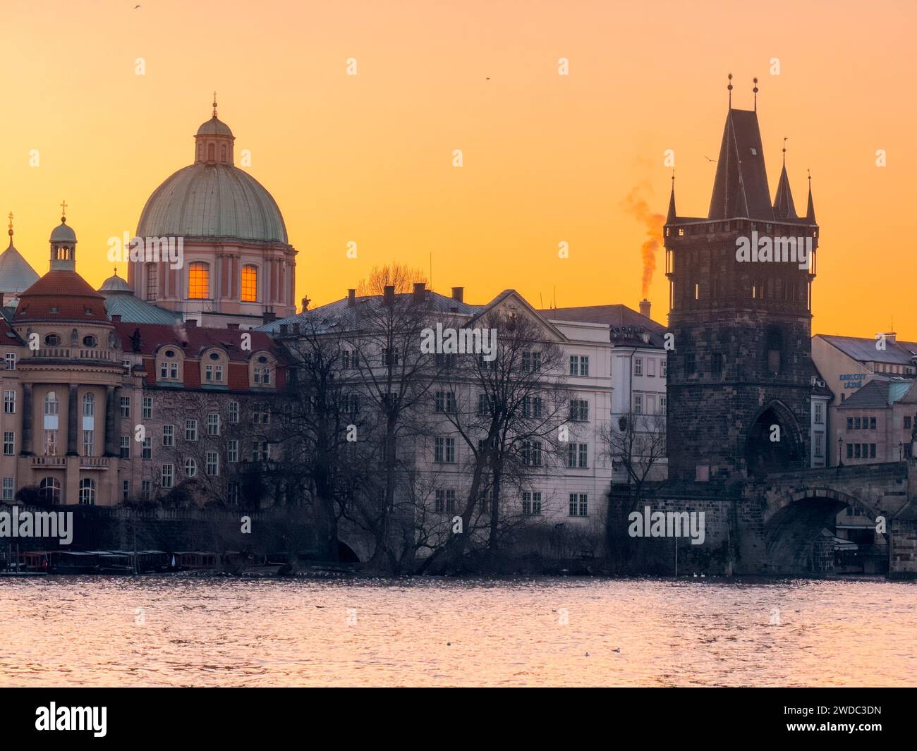 Aube glaciale en hiver sur Prague. Lueur dorée pittoresque et brume hivernale sur la rivière Vltava avec pont et ville historique autour. Prague, République tchèque Banque D'Images