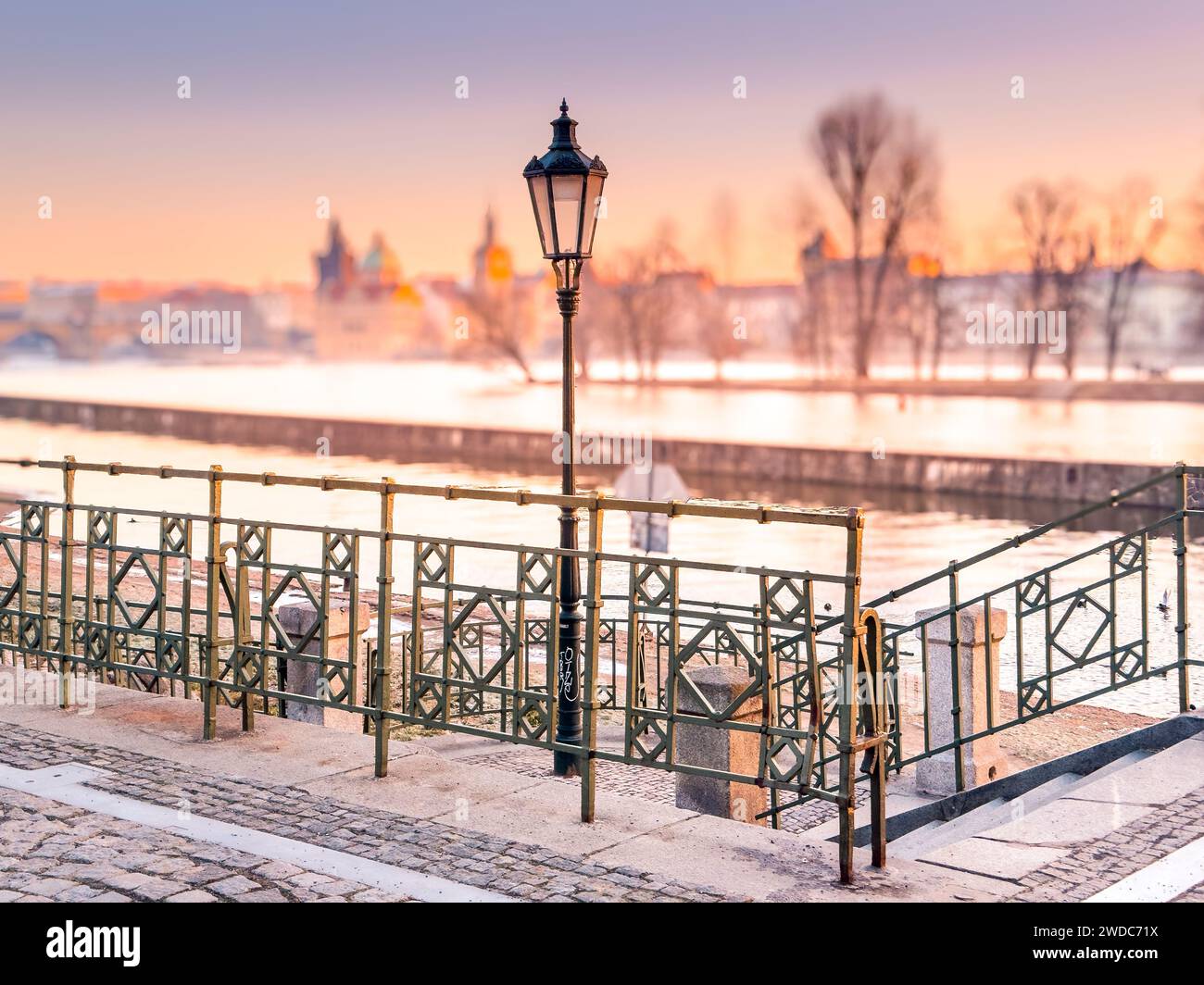 Aube glaciale en hiver sur Prague. Lueur dorée pittoresque et brume hivernale sur la rivière Vltava avec pont et ville historique autour. Prague, République tchèque Banque D'Images