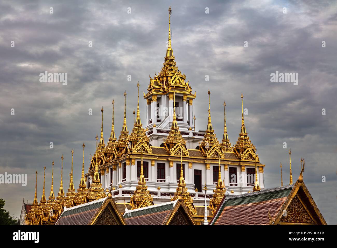 Temple en métal (Wat Ratchanatdaram) à Bangkok, Thaïlande. Flèches métalliques sur le toit. Ciel nuageux sombre au-dessus de nous Banque D'Images