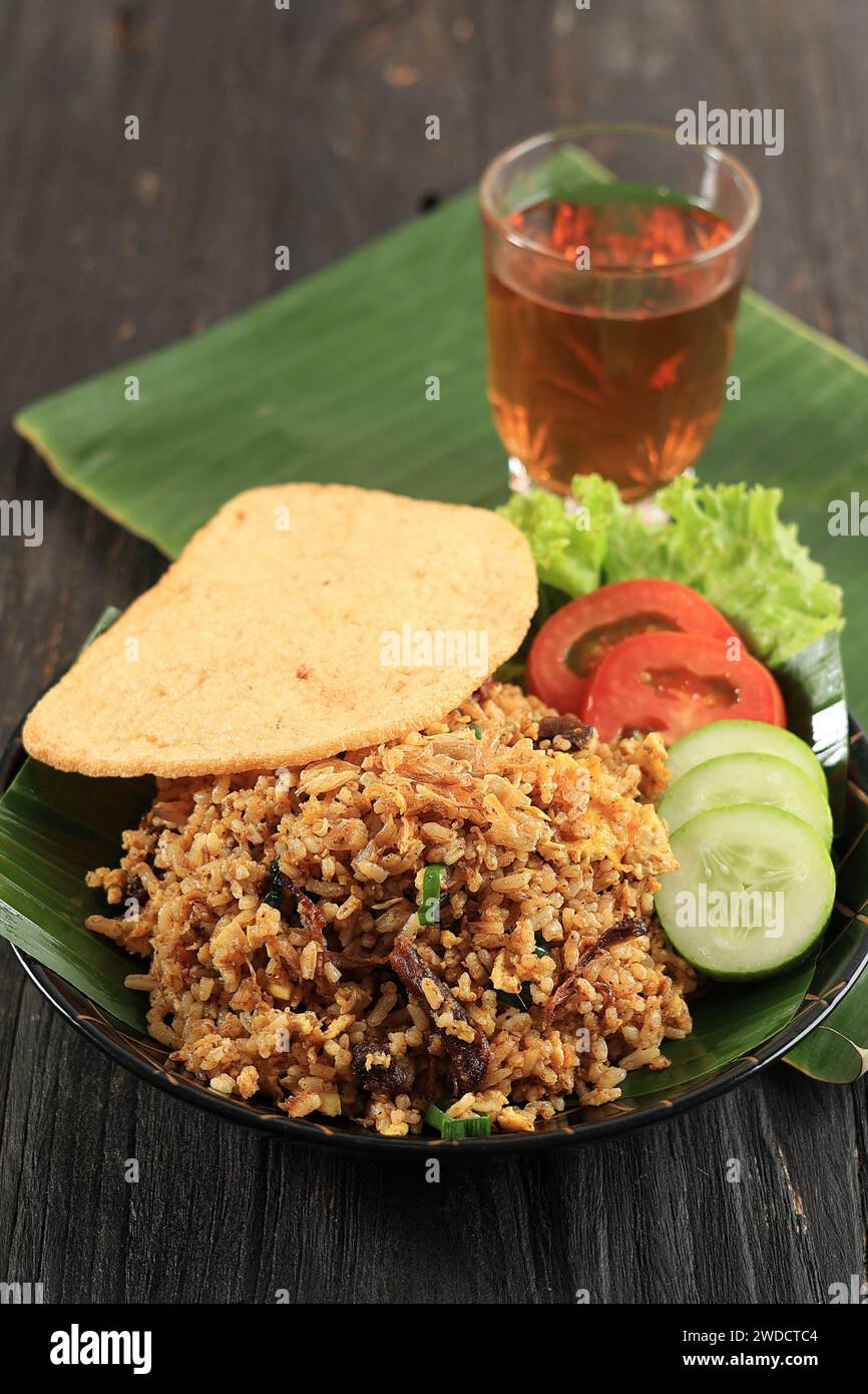 Nasi Goreng Rendang avec craquelin aux crevettes et thé chaud, Rendang est un ragoût de bœuf traditionnel Melayu Minang. Riz frit rendang Banque D'Images