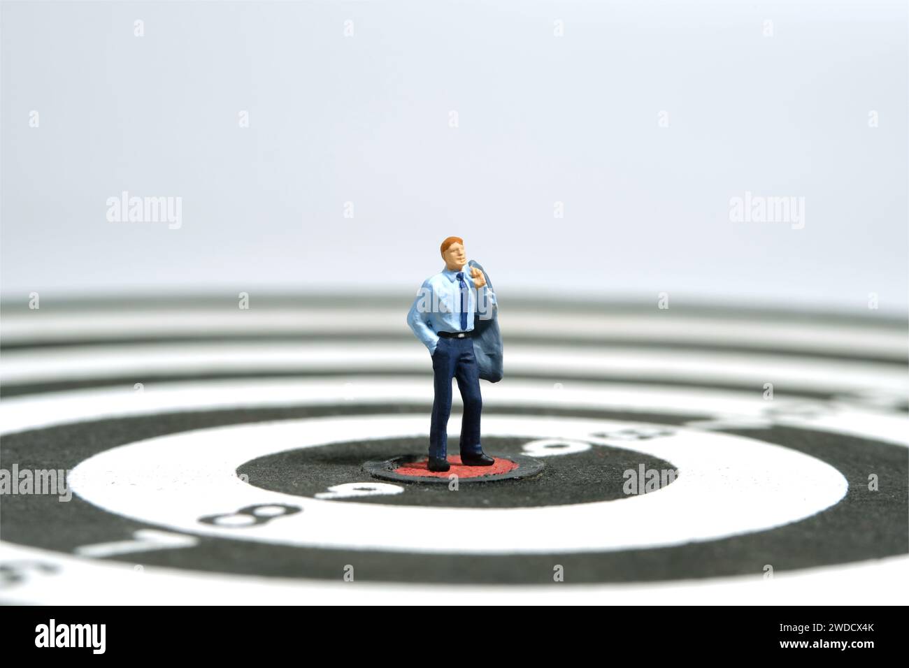 Photographie miniature de figurine de jouet de personnes minuscules. Illustration du concept d'entreprise. Un homme d'affaires debout au centre de fléchettes, pensant la stratégie effe Banque D'Images