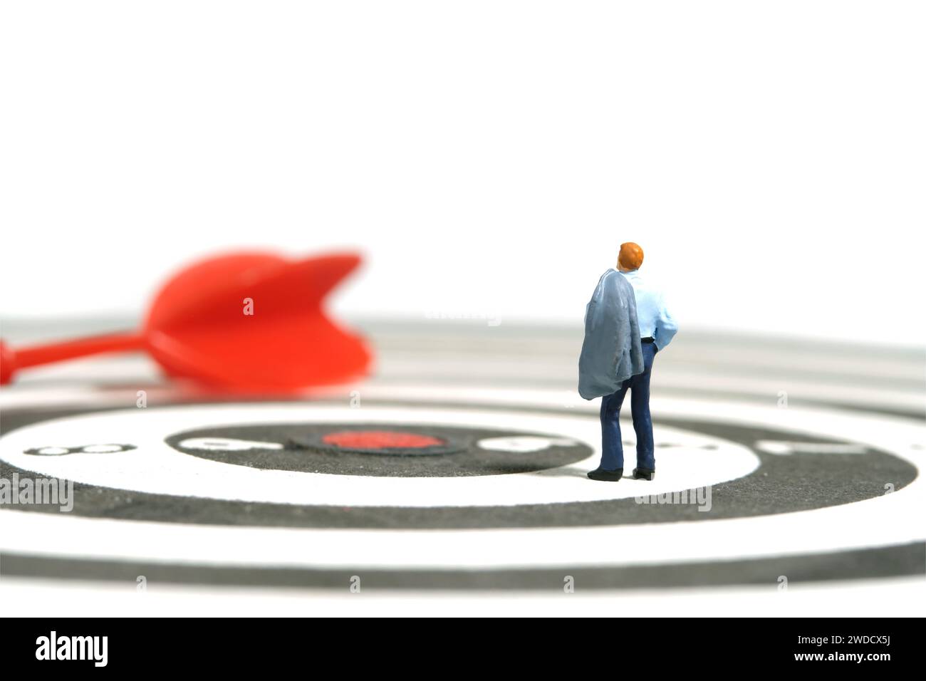 Photographie miniature de figurine de jouet de personnes minuscules. Illustration du concept d'entreprise. Un homme d'affaires debout au-dessus du jeu de fléchettes avec la flèche rouge, pensant la stratégie Banque D'Images