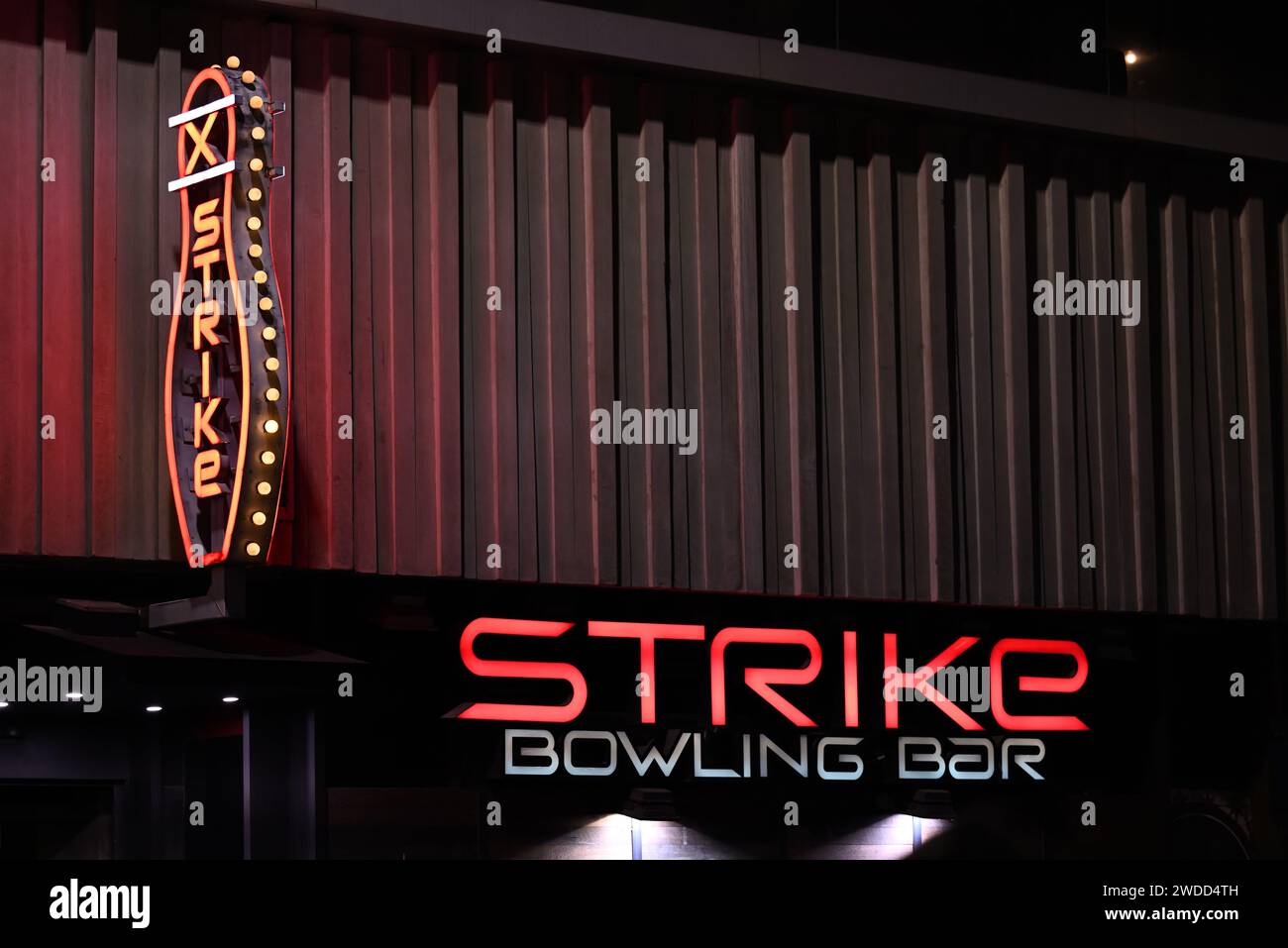 Signalisation lumineuse principalement rouge, avec un panneau ressemblant à une quille à bowling, à l'extérieur du Strike Bowling Bar à QV la nuit Banque D'Images
