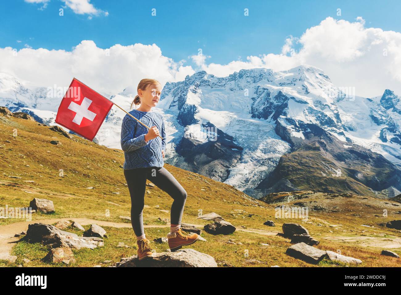 Mignonne petite fille tenant le drapeau suisse, debout devant le glacier Gornergrat, Suisse Banque D'Images