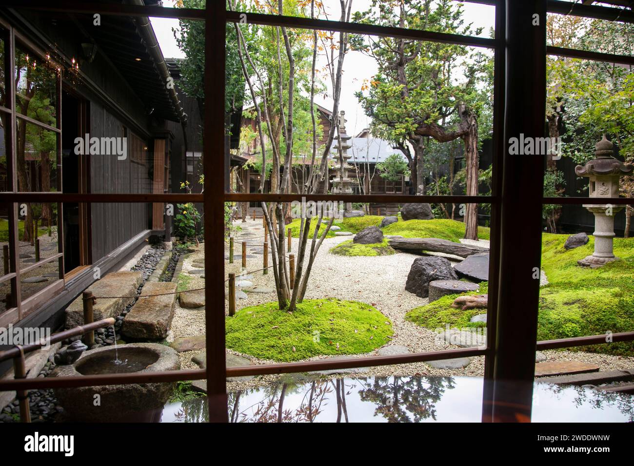 Jardin japonais traditionnel avec une sculpture en pierre dans une maison de thé traditionnelle dans la ville de Murakami au Japon. Banque D'Images