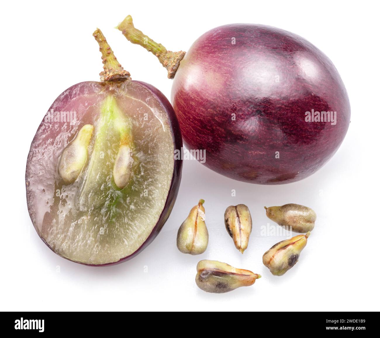 Baies de raisin de table rouge et pépins de raisin isolés sur fond blanc. Banque D'Images
