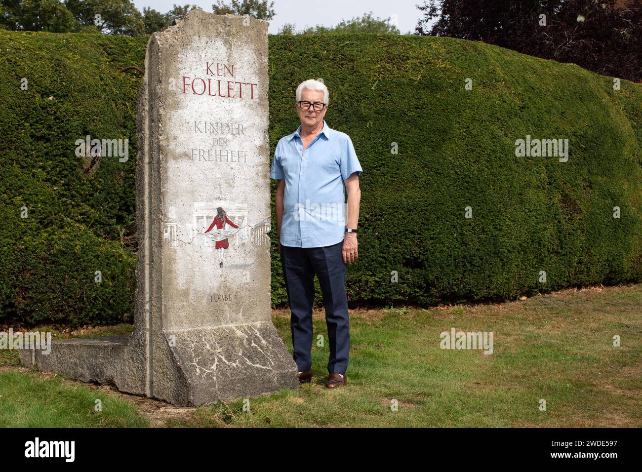 Ken Follett debout à côté d'une section du mur de Berlin dans son jardin. Stevenage, Hertfordshire, Royaume-Uni . Banque D'Images