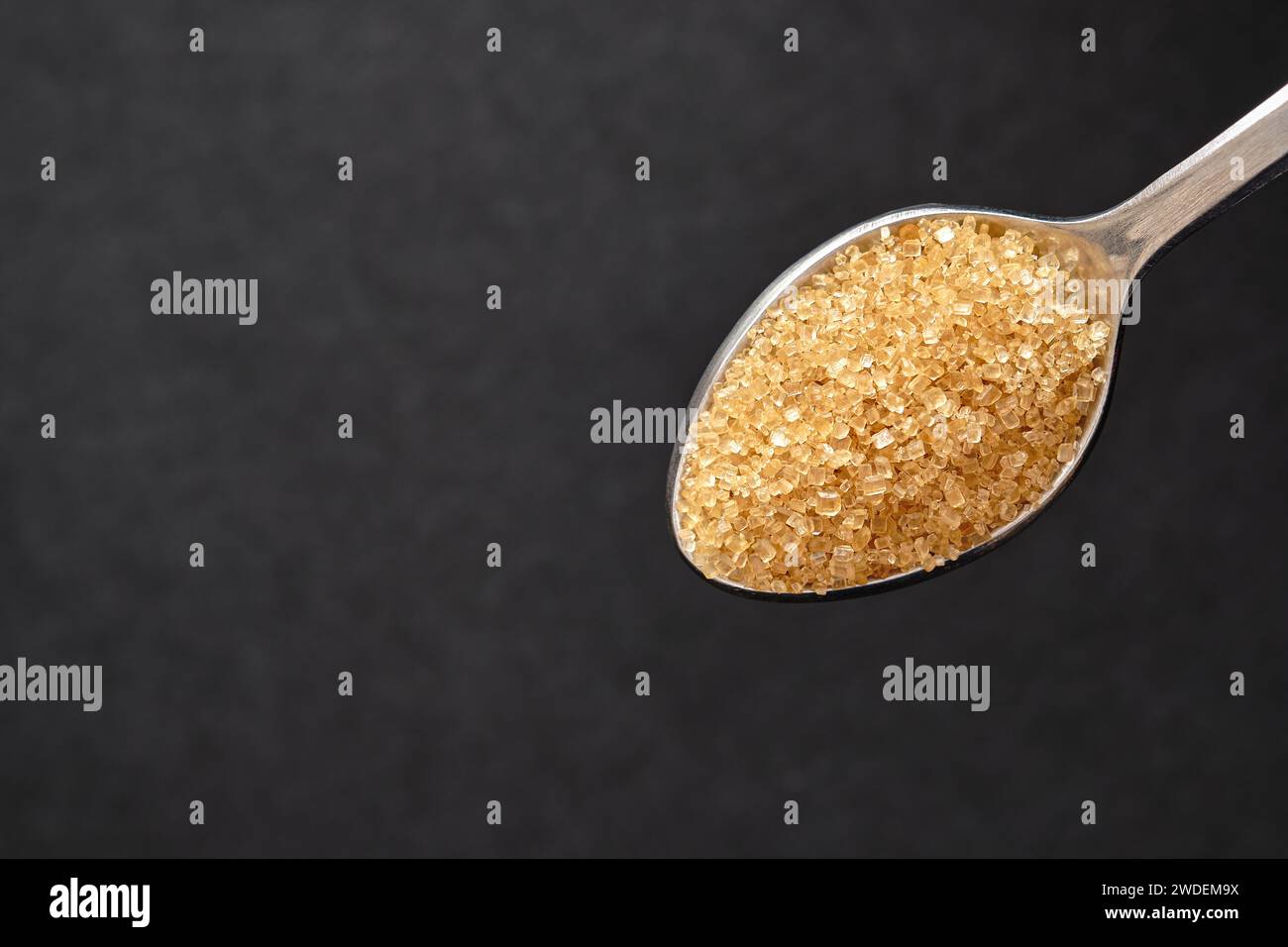 Vue de dessus, cuillère à café de sucre brun, gros plan de l'espace de copie de sucre de canne pour le texte. Banque D'Images