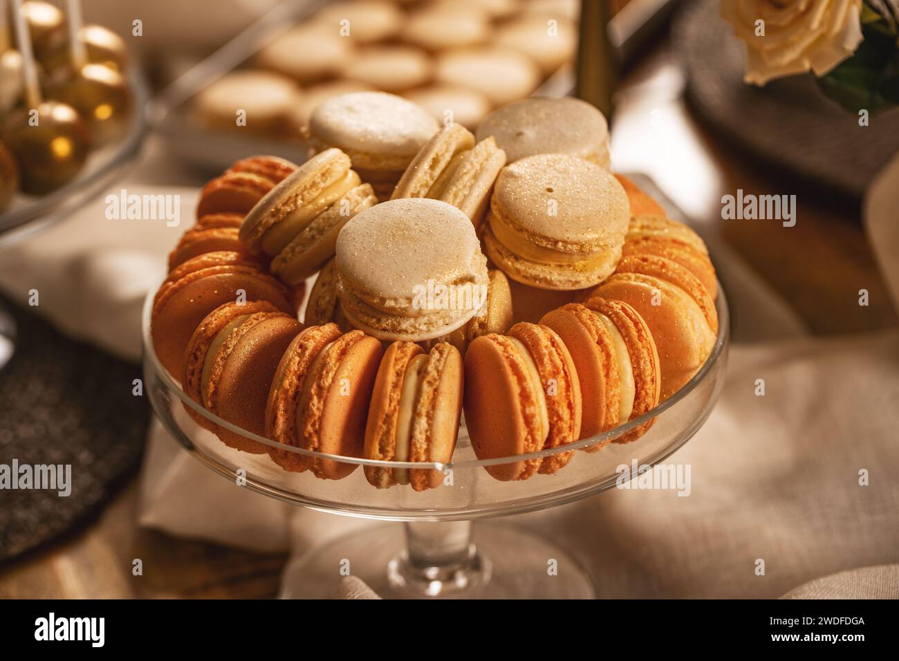 Macarons de couleur pastel dans un élégant bol en verre sur une table sucrée Banque D'Images