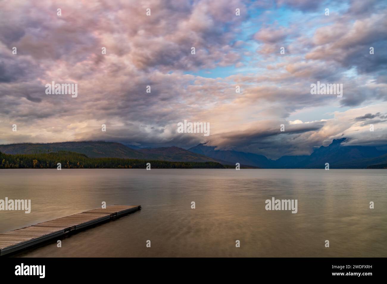 Coucher de soleil sur le lac McDonald avec reflets et quai, Glacier National Park, Montana, États-Unis. Banque D'Images