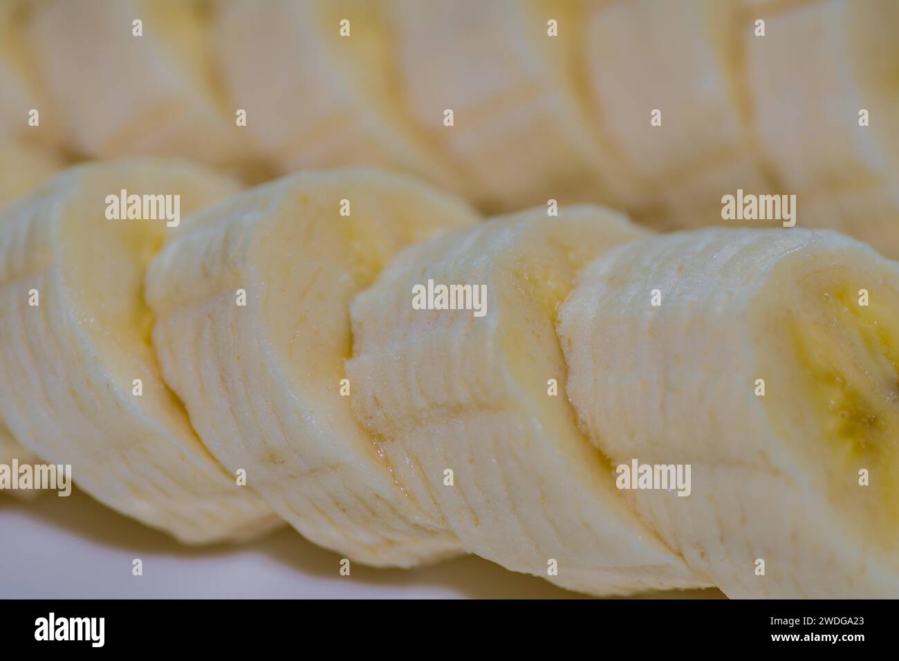 Tranches de bananes fraîches coupées en tranches sur un plat blanc Banque D'Images