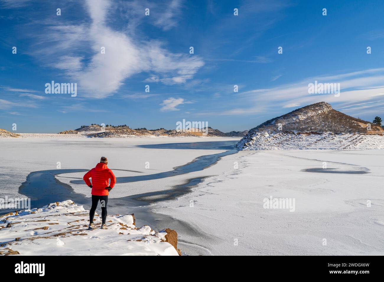 Randonneur masculin en duvet sur un rivage rocheux du réservoir Frozen Horsetooth dans le nord du Colorado Banque D'Images