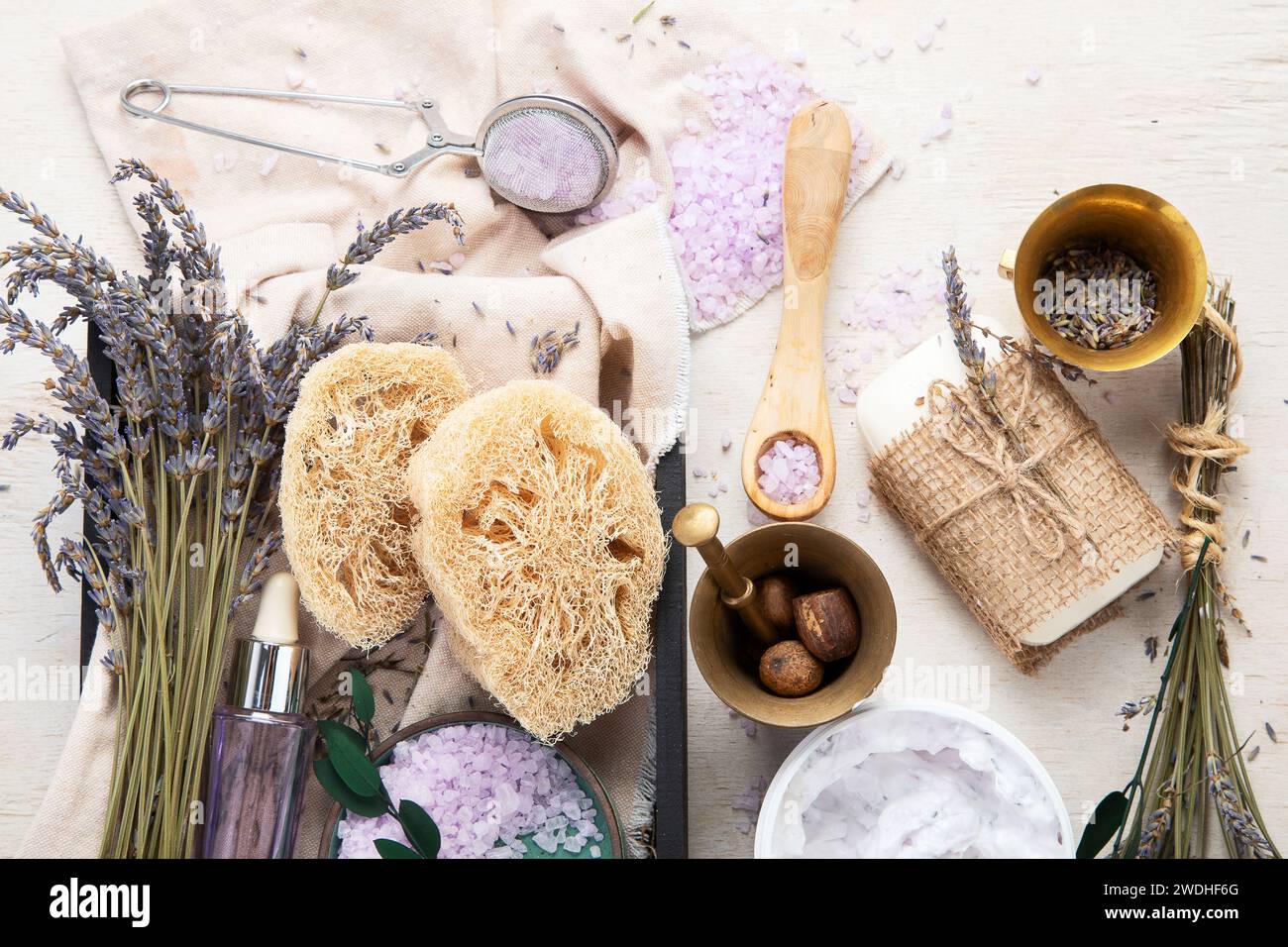 Concept cosmétique biologique, bouteille en verre avec huile, pipette et fleurs de lavande, gommage sur fond clair. Cosmétique maison et concept de beauté. Haut Banque D'Images