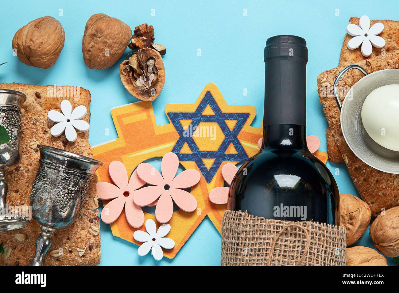 Concept de célébration de la Pâque. Matzah, noix casher rouge et printemps de belles fleurs sur un fond bleu. Pain juif rituel traditionnel. Banque D'Images