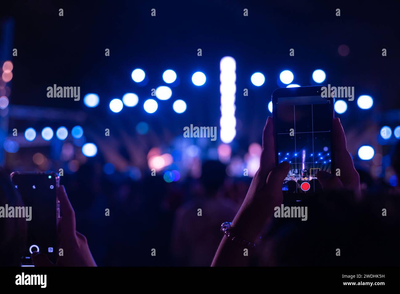 Un festival de concert animé la nuit avec une foule acclamée méconnaissable devant le brillamment Banque D'Images