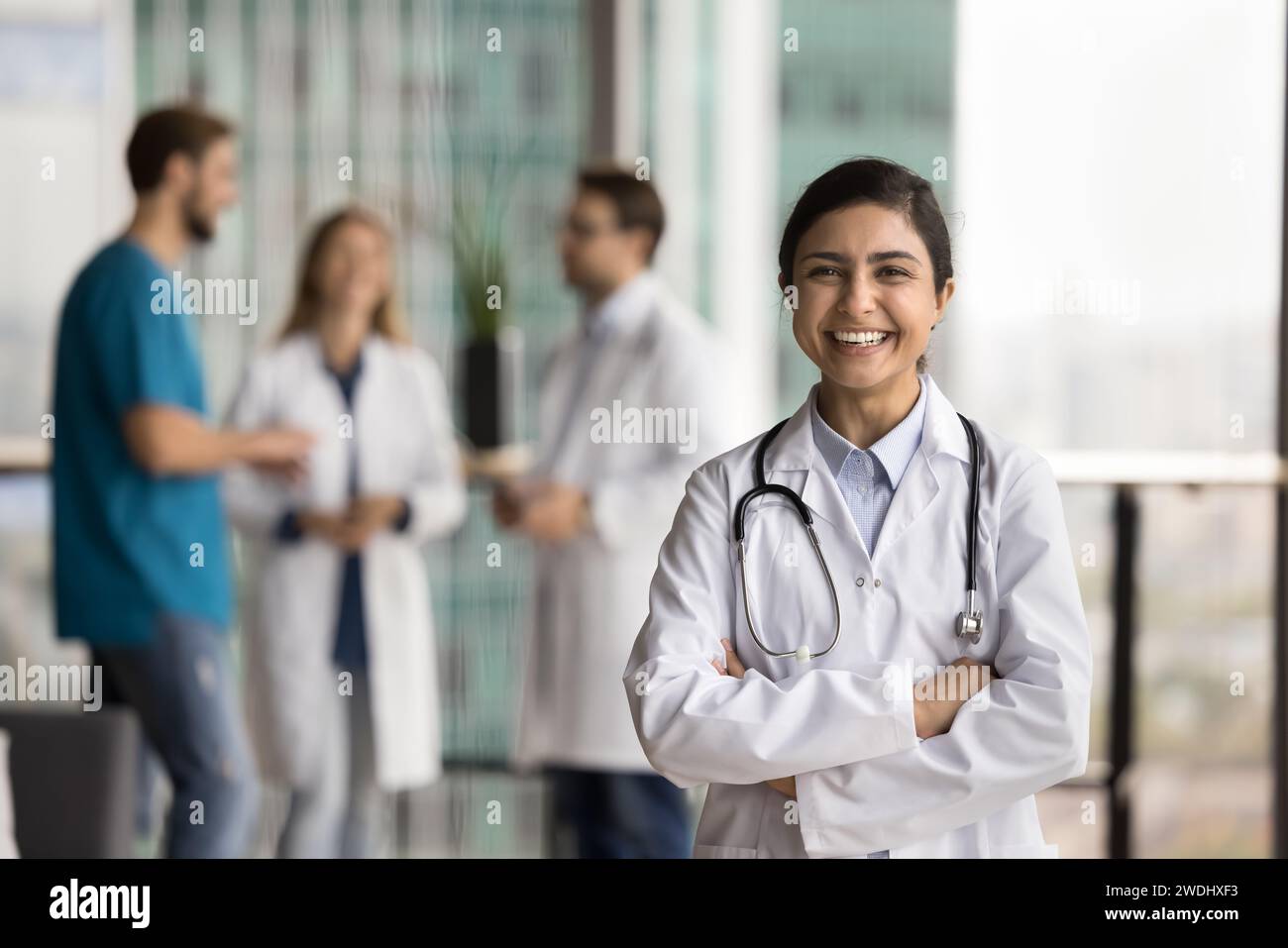Joyeuse belle femme médecin indienne en uniforme appréciant l'occupation médicale Banque D'Images