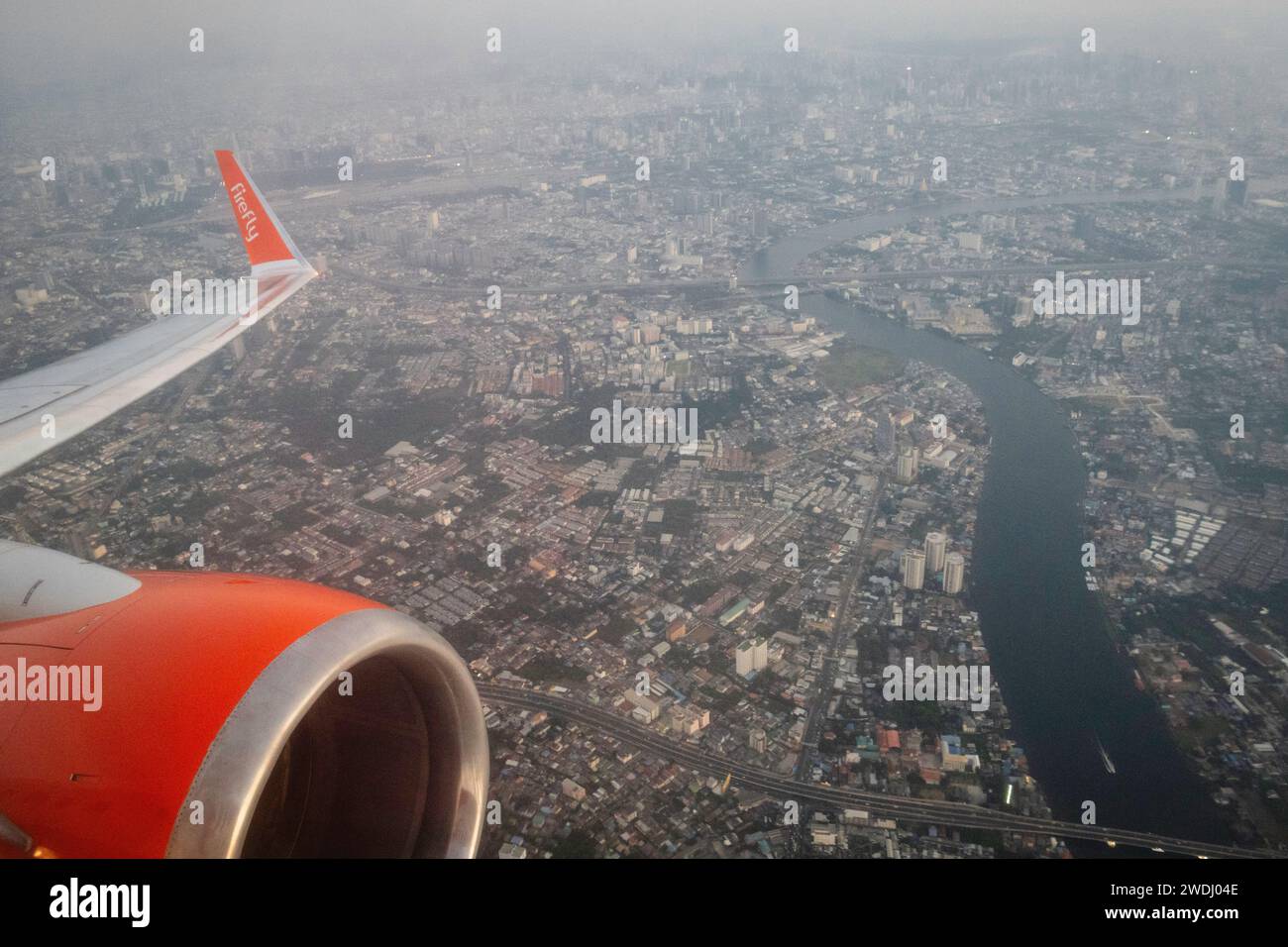 Bangkok, Thaïlande. 15 janvier 2024. Une vue aérienne de Bangkok depuis une fenêtre d'avion qui vient de décoller de l'aéroport Don Mueang, avec le logo sur l'aile de l'avion de la compagnie Firefly Airlines. L'aéroport international Don Mueang est l'un des deux aéroports internationaux desservant la région métropolitaine de Bangkok. (Photo Nathalie Jamois/SOPA Images/Sipa USA) crédit : SIPA USA/Alamy Live News Banque D'Images