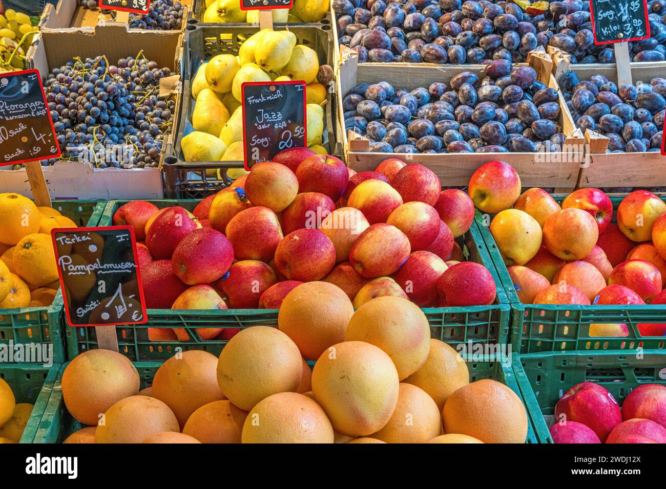 Oranges, pommes et prunes en vente sur un marché Banque D'Images