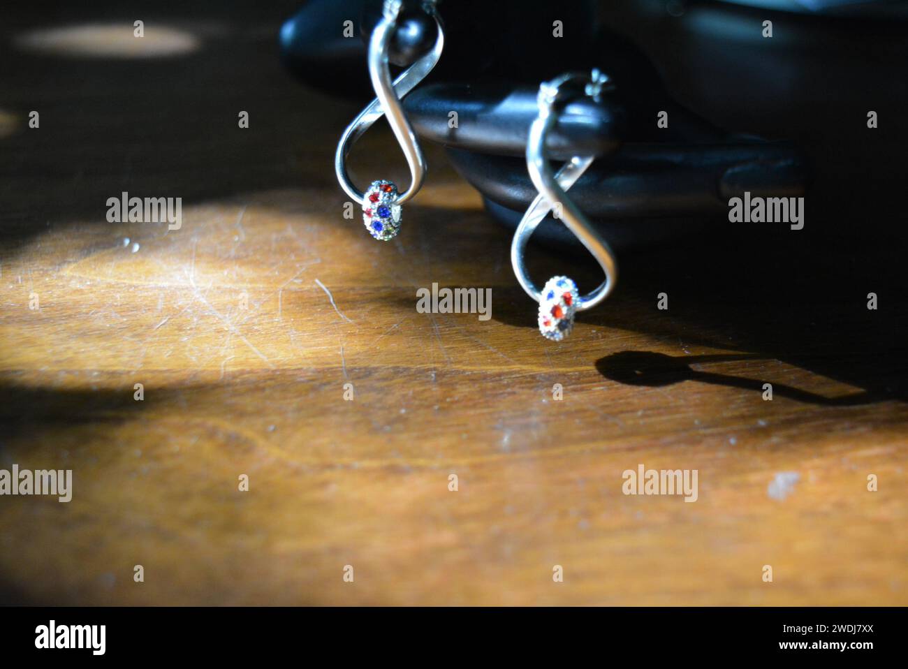 Statuette noire d'une main féminine mate avec boucles d'oreilles en argent avec de belles pierres et un pendentif. Banque D'Images