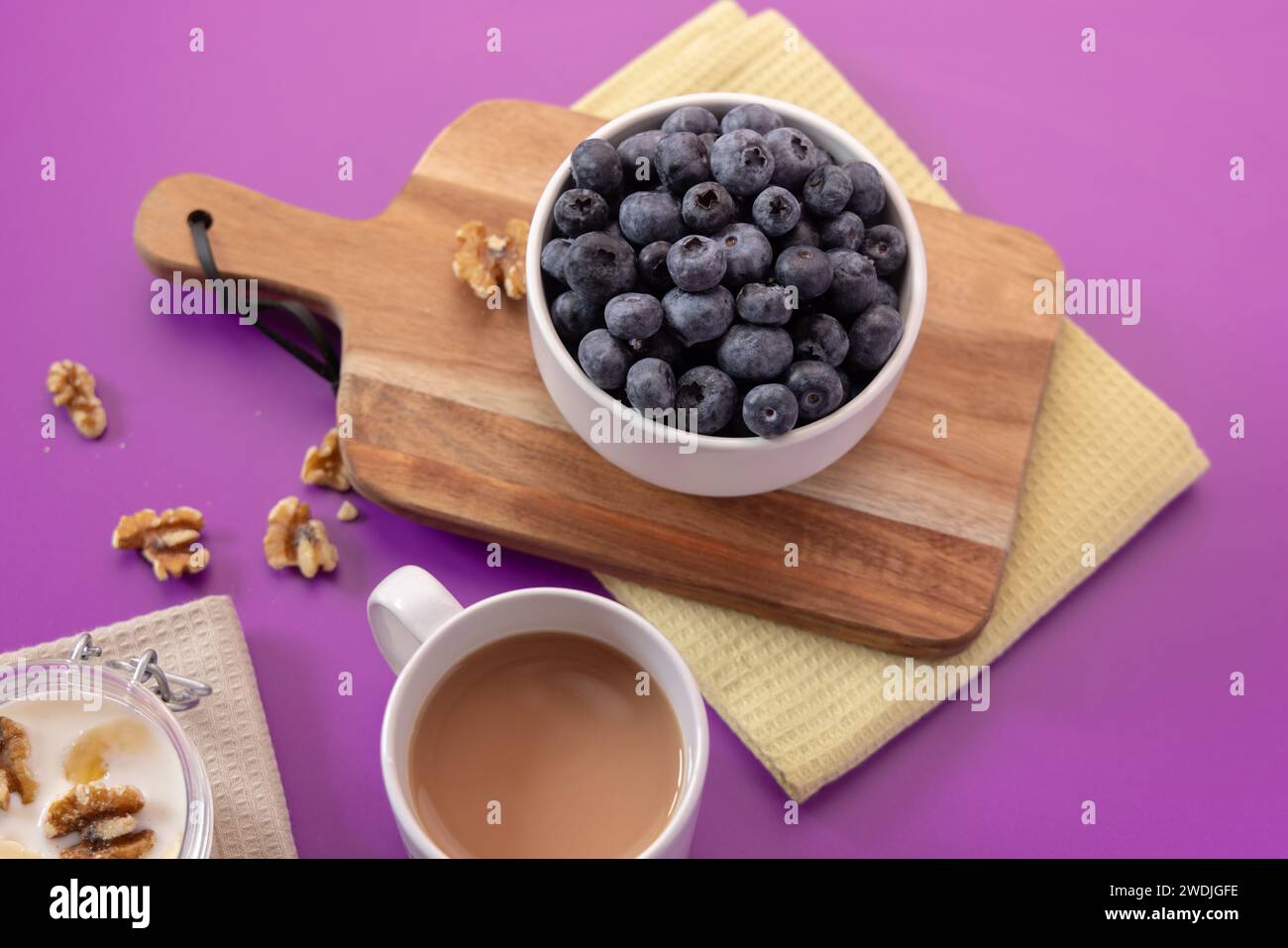 Photo de nourriture saine avec porridge, myrtilles, banane, cannelle et noix avec attrezo Banque D'Images