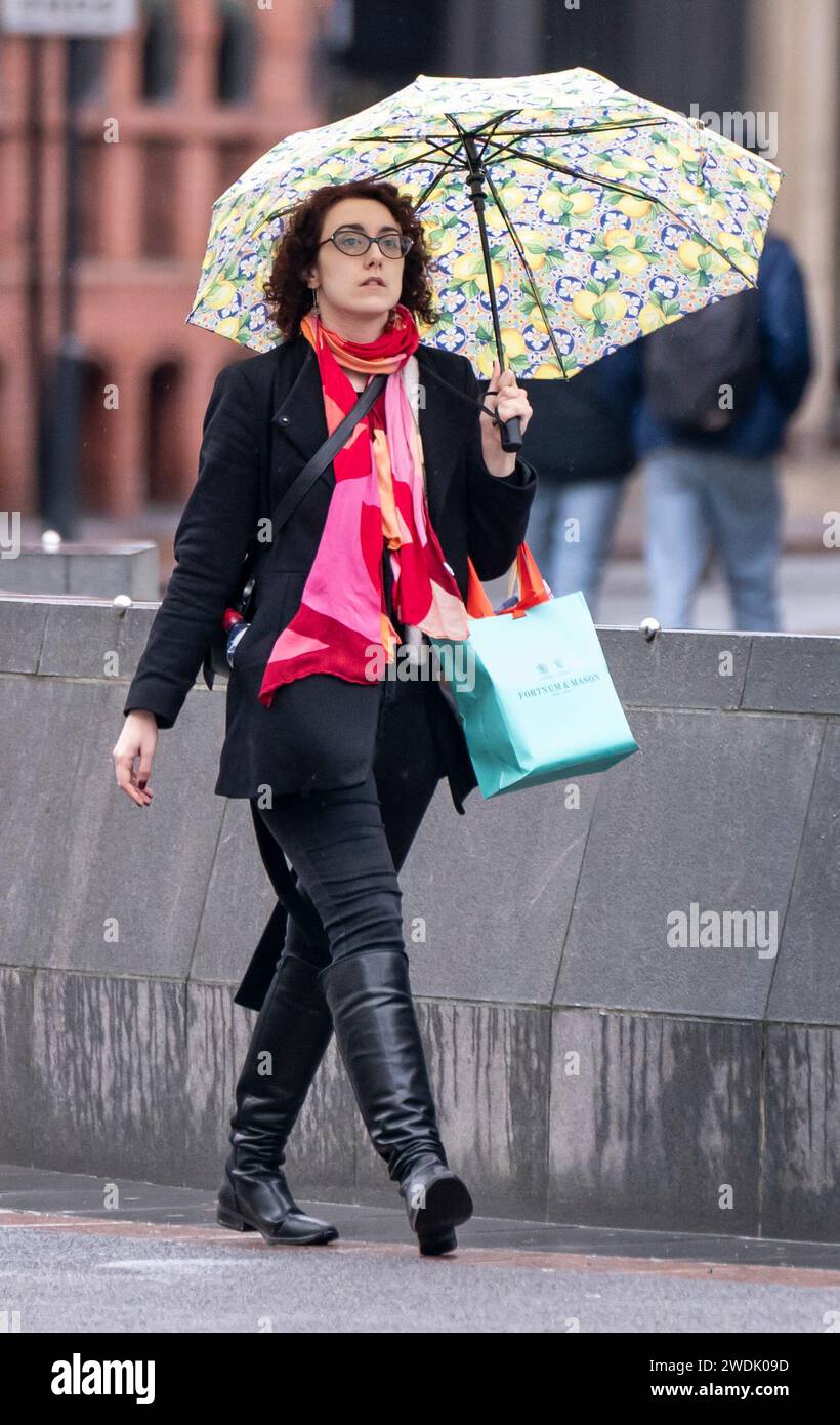 Une femme avec un parapluie à Leeds. Le Royaume-Uni est couvert par des avertissements de vent « inhabituels » de danger pour la vie à l'approche de la tempête Isha, et les gens sont avertis de ne pas voyager en présence de rafales de 90 km/h. Date de la photo : dimanche 21 janvier 2024. Banque D'Images