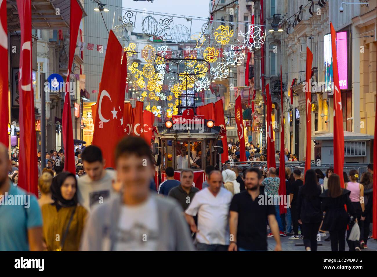 Drapeaux turcs avec tramway nostalgique et personnes dans l'avenue Istiklal. Istanbul Turkiye - 10.28.2023 Banque D'Images