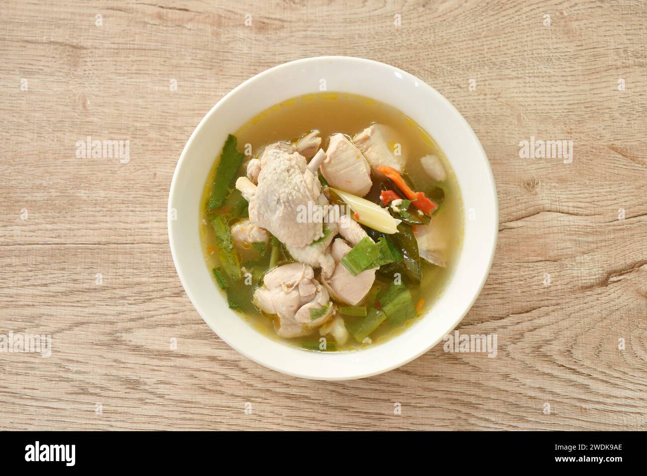 poulet bouilli épicé et os avec de la soupe tom yum de feuilles d'herbes sur un bol Banque D'Images