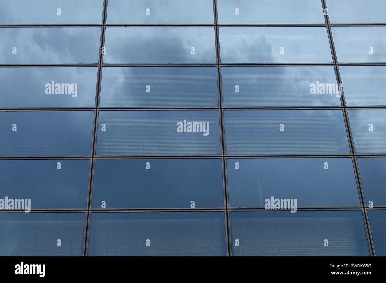 Façade en verre de bâtiment moderne avec des reflets de ciel abstrait. Banque D'Images