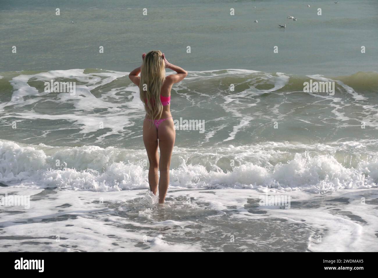Non exclusive : ODESA, UKRAINE - 19 JANVIER 2024 - Une femme en bikini se tient à la cheville dans la mer Noire lors de la célébration de l'Epiphanie basée sur Banque D'Images