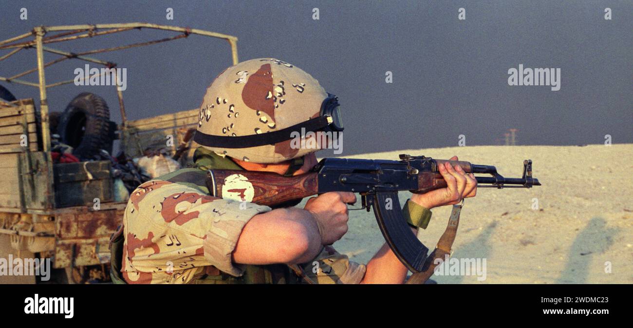 5 mars 1991 Un soldat de la coalition tire un fusil irakien AK-47 Kalachnikov dans le désert sur la route d'Um Qasr au Koweït. Banque D'Images