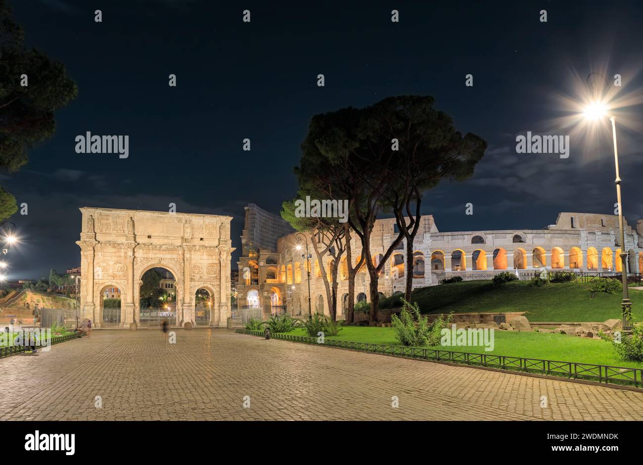 Paysage urbain nocturne de Rome : vue du Colisée et de l'Arc de Constantin, Italie. Banque D'Images