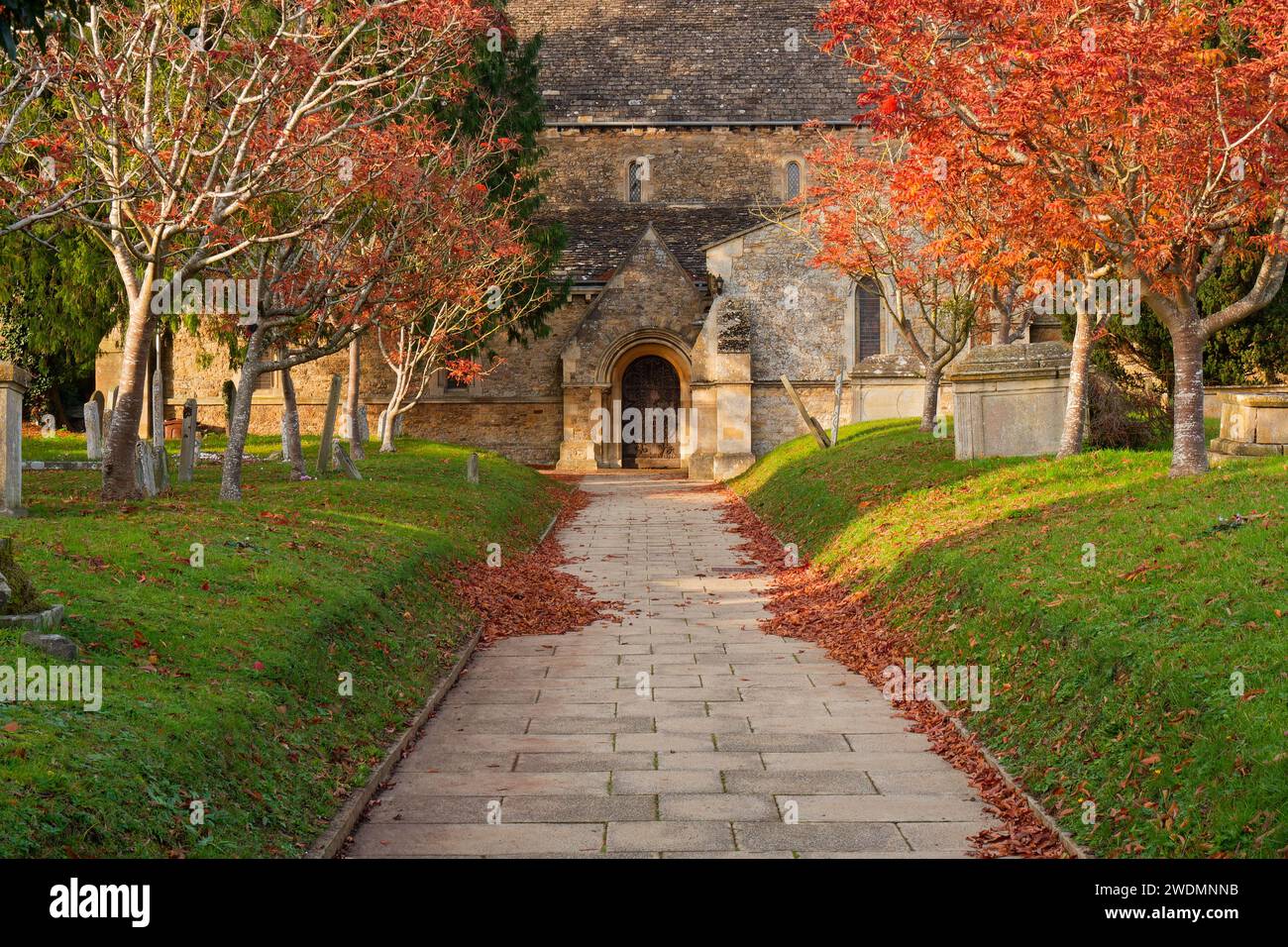 Sentier entre cimetière surélevé vers une porte d'église en automne - Faringdon, Oxfordshire, Angleterre Banque D'Images
