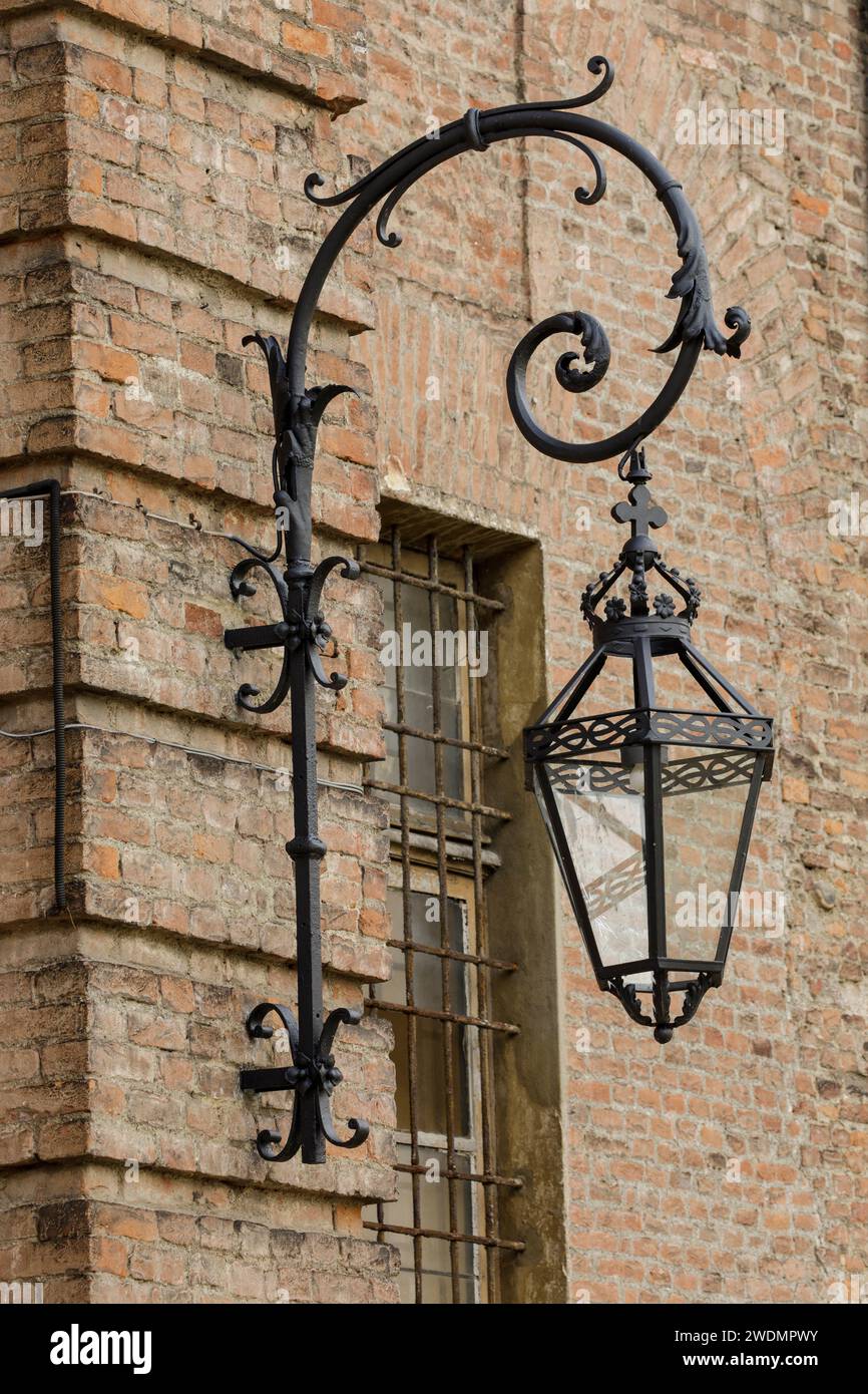 Lanterne en fonte ornée avec couronne et croix et ampoule moderne sur un mur de briques au Palazzo Reale, Turin Italie Banque D'Images