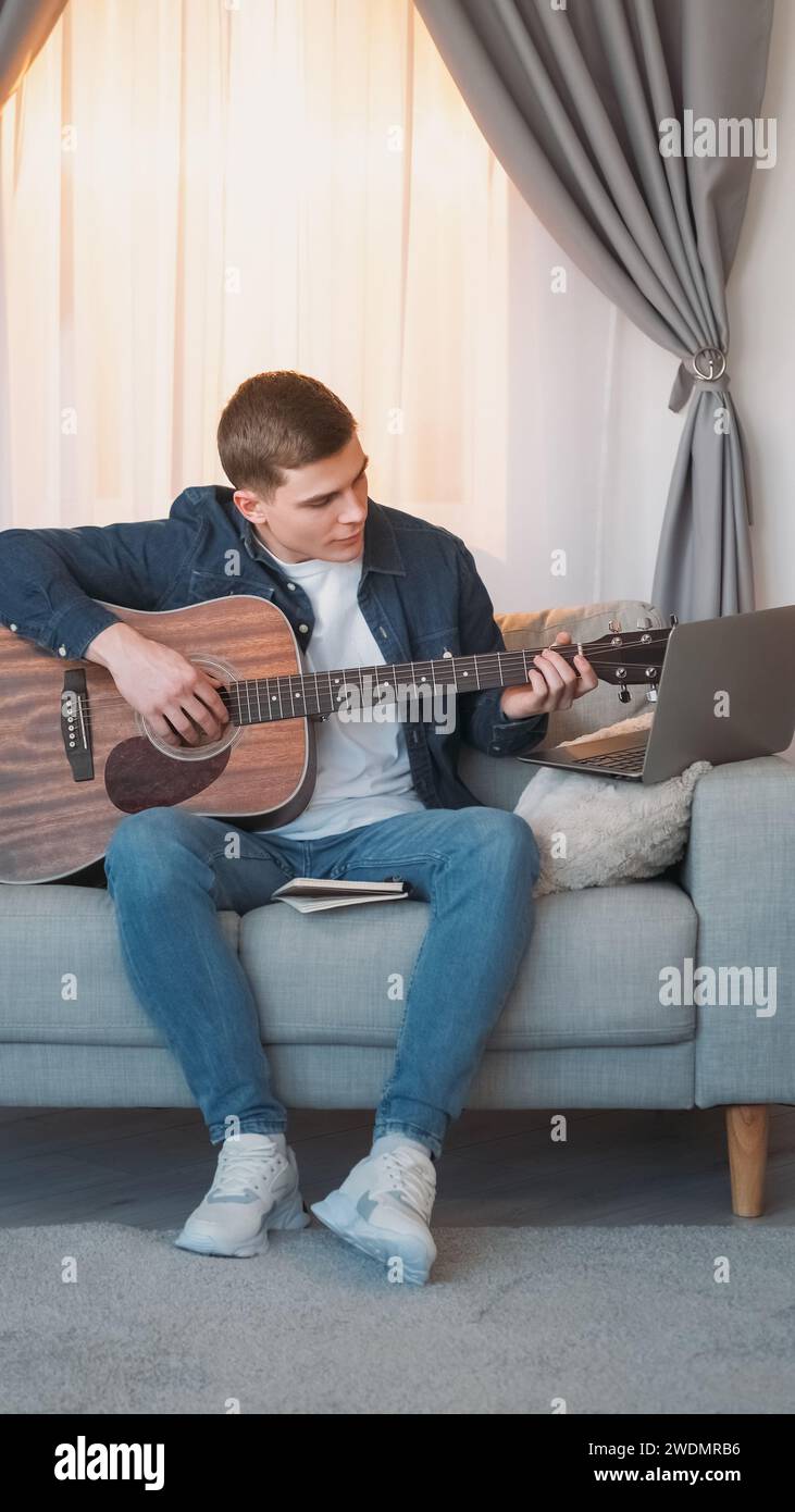 Cours de guitare Internet classe musique homme ordinateur portable maison Banque D'Images
