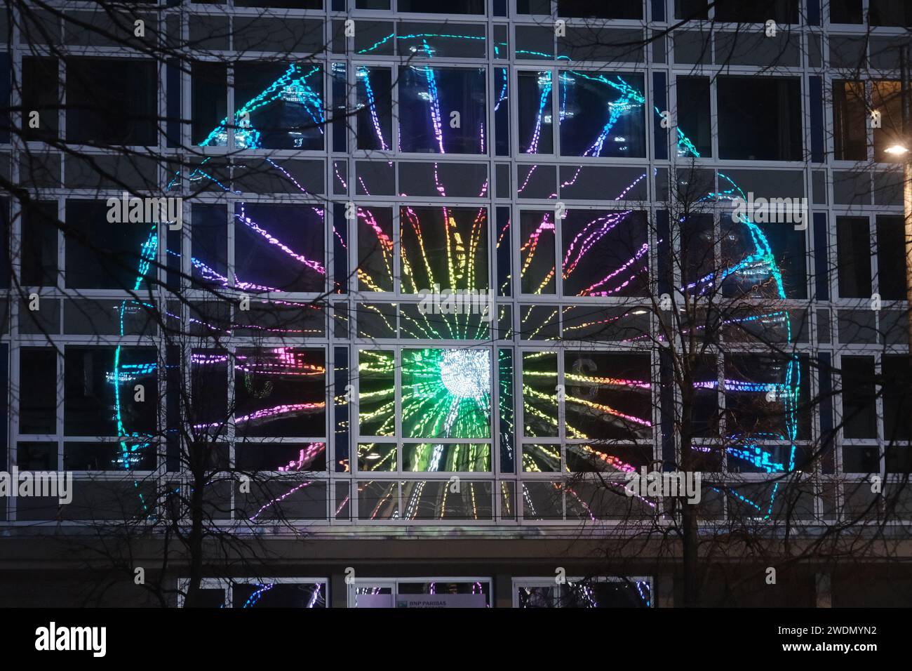 Leipzig, Allemagne. 21 janvier 2024. Une grande roue illuminée se reflète dans la façade vitrée de l'ancien bureau de poste principal sur Augustusplatz. Le trajet fait partie du « Leipzig Ice Dream ». Selon les organisateurs, la plus grande ronde, patinoire mobile en Allemagne attire les visiteurs à patiner jusqu'au 03.03.2024. Crédit : Sebastian Willnow/dpa/Alamy Live News Banque D'Images