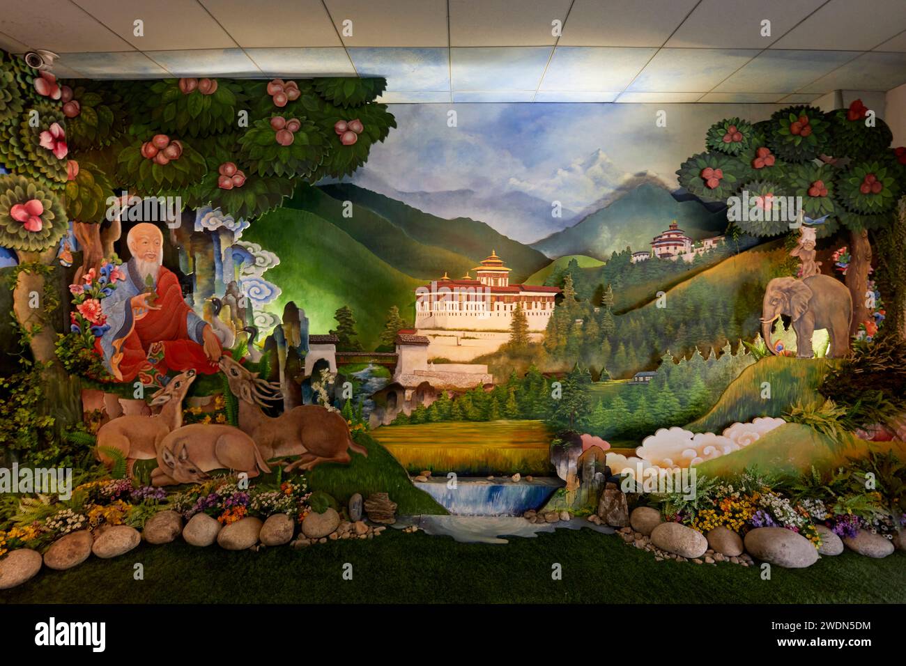 Des peintures de scènes rurales et l'emblématique Paro Dzong (fort) en guise de bienvenue au Royaume du Bhoutan sont exposées dans le hall des arrivées de l'aéroport de Paro, au Bhoutan Banque D'Images