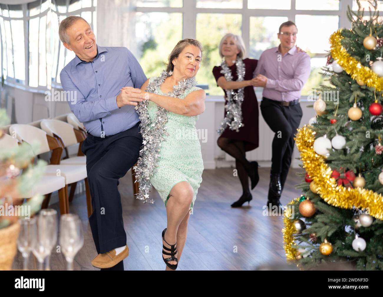 Heureux homme adulte caucasien et dame dansant rock and roll danse dans le studio de danse pendant la célébration Noël et nouvel an Banque D'Images