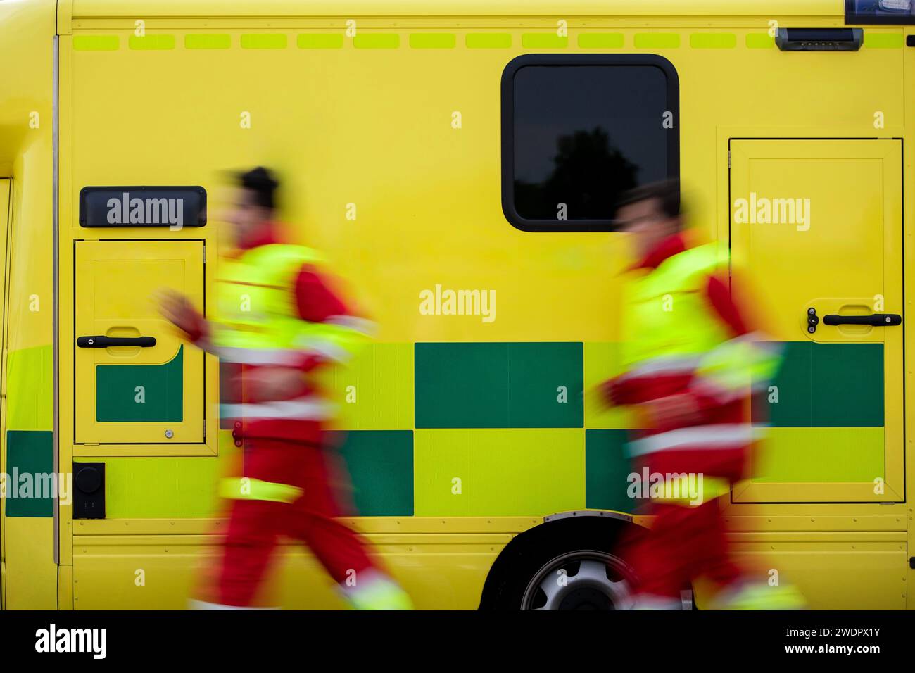 Équipe deux paramédical courant à la voiture ambulance du service médical d'urgence. Thèmes sauvetage, urgence et soins de santé. Banque D'Images