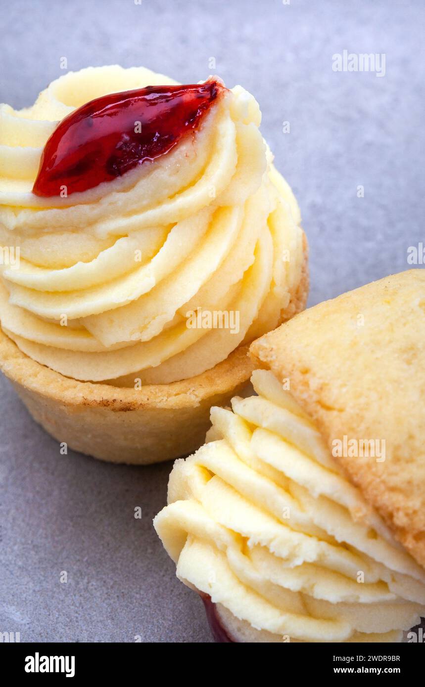 Mini tartelettes au fromage avec garniture de fraise sur une surface grise tachetée avec culture abstraite et mise au point sélective Banque D'Images
