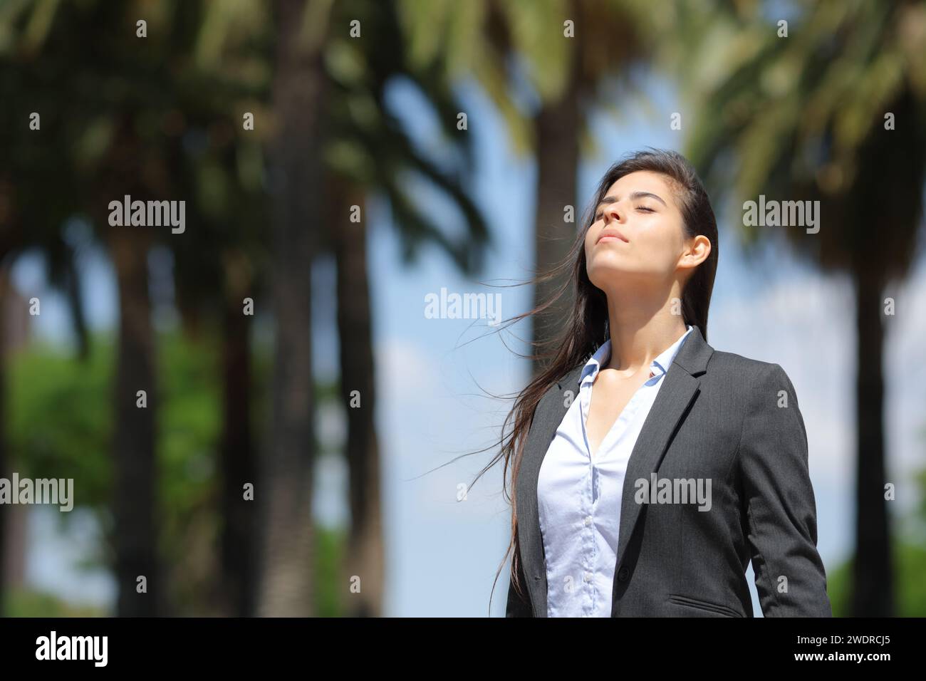 Femme d'affaires respirant l'air frais debout dans un parc Banque D'Images